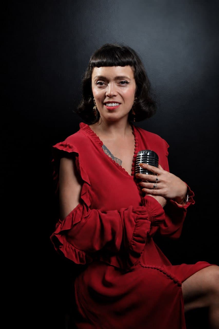 Melissa Lesnie en robe rouge au microphone